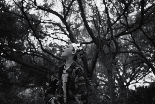 A young boy howls in the woods, while wearing a plastic fast food crown on his head. From the film 'The School Duel'